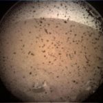Prima fotografie trimisă de Insight de pe Marte, de o cameră instalată sub modul, la câteva momente după amartizare. Punctele negre reprezintă praful așezat pe lentila de protecție. Foto: NASA