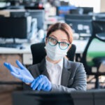 Female,Office,Manager,In,A,Medical,Mask,Puts,On,Gloves
